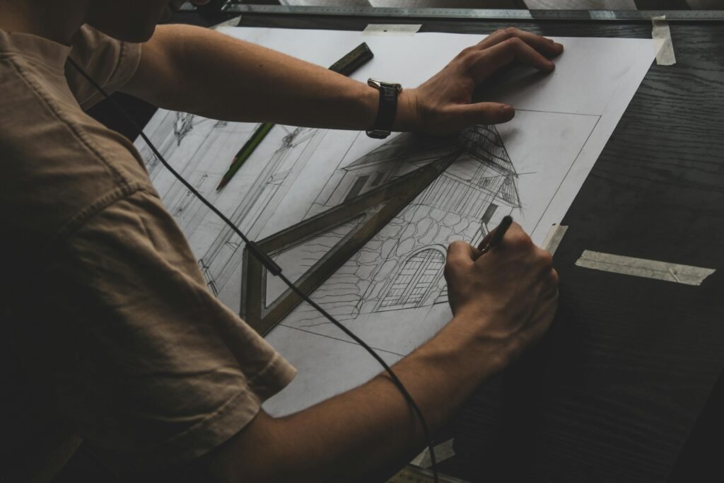 Architectural Drawing Process Person drawing an architectural plan by hand with a pencil and set squares.