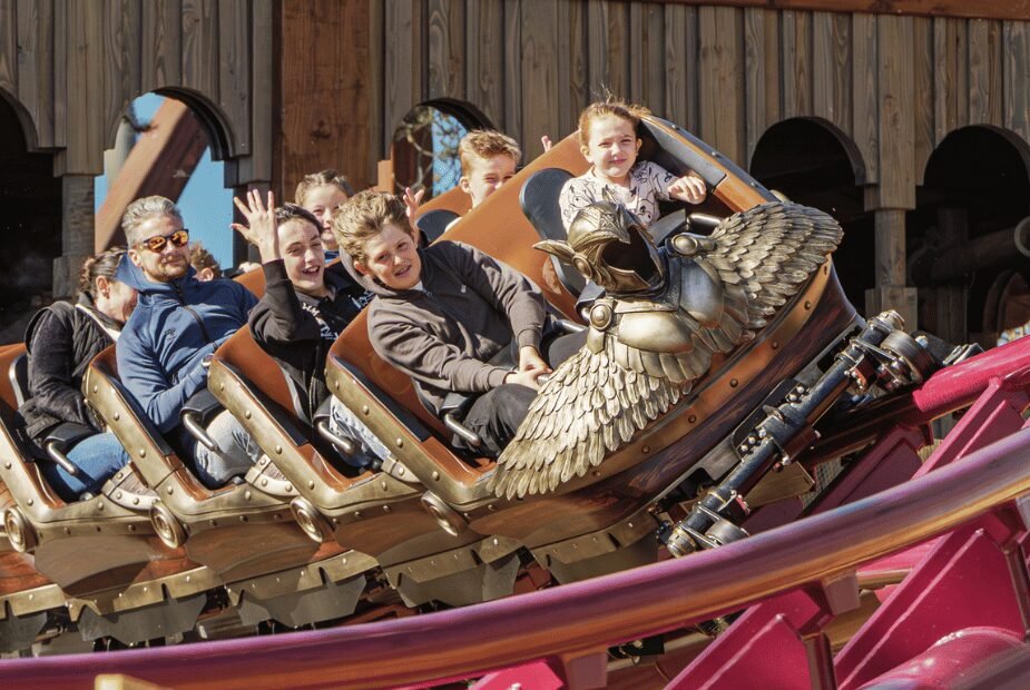 Guests riding Valkyrie at Festyland in a Viking-themed coaster train with a sculpted winged figure at the front.